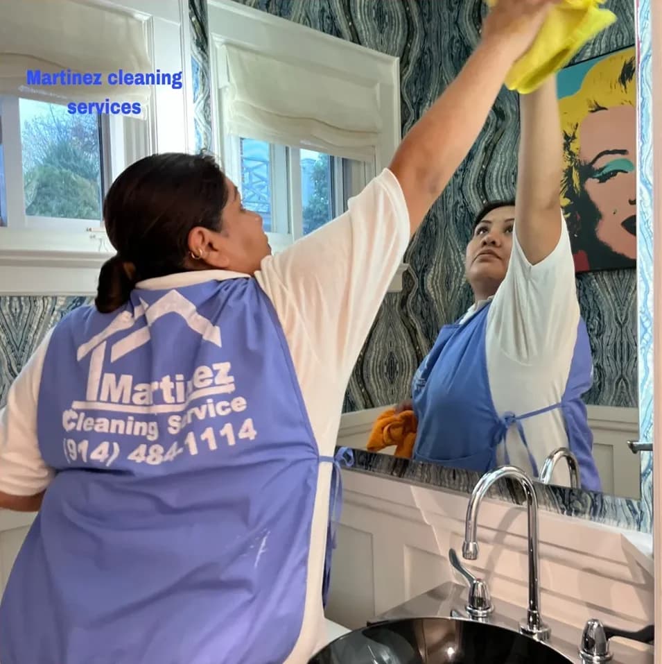 Erica Martinez, founder of Martinez Cleaning Services, cleaning a client's bathroom mirror